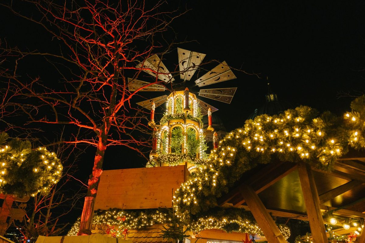 A German Christmas market at night with an illuminated Christmas pyramid