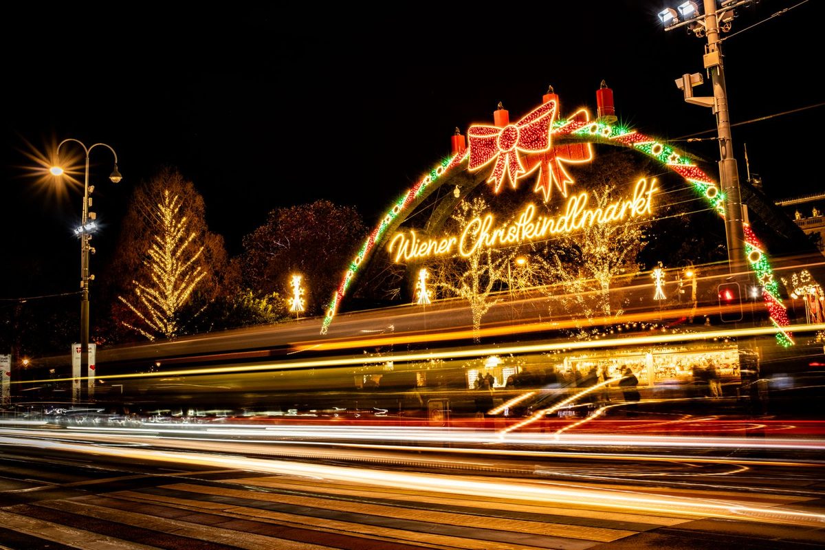 An illuminated Wiener Christkindlmarkt archway at night in Vienna, Austria