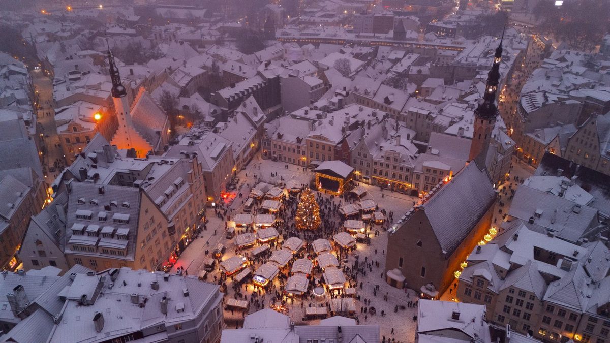 Aerial view of the snow-covered Tallinn old town and Christmas market at dusk